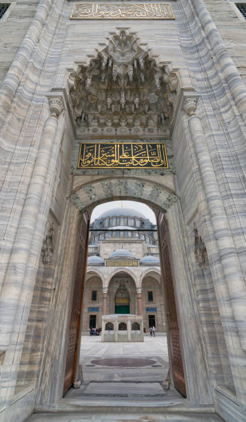 tir de jour faible angle d’une des entrées menant à la cour de la mosquée suleymaniye, doté d’une façade principale de la mosquée et peu de touristes visitant la mosquée, istanbul, turquie - istanbul surrounding wall suleymanie mosque turkey photos et images de collection