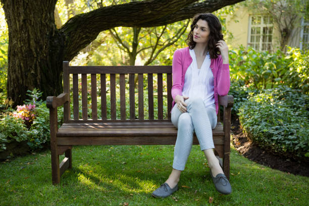 istock Thoughtful woman sitting on park bench 819959032
