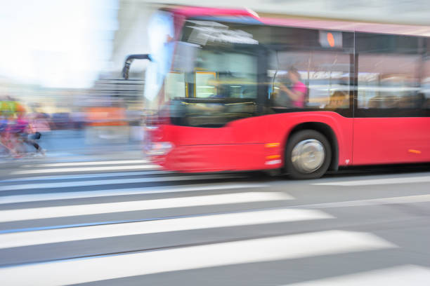 City bus in profile / silhouette driving fast through motion blurred background.