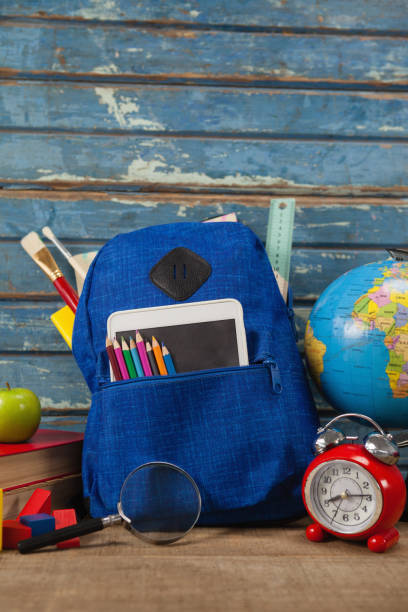 istock School supplies, apple, globe, digital tablet and magnifying glass on wooden table 820014664