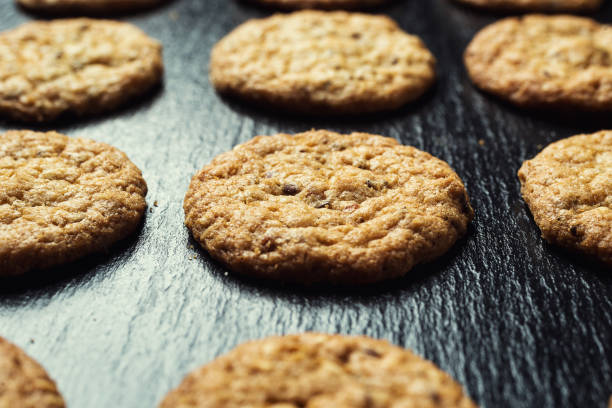 istock Biscuit sweet cookie background. Domestic stacked butter biscuit pattern concept,close up macro.Homemade cookies on wooden table.Cereal biscuits with the sesame,peanuts,sunflower and amaranth. 820017934