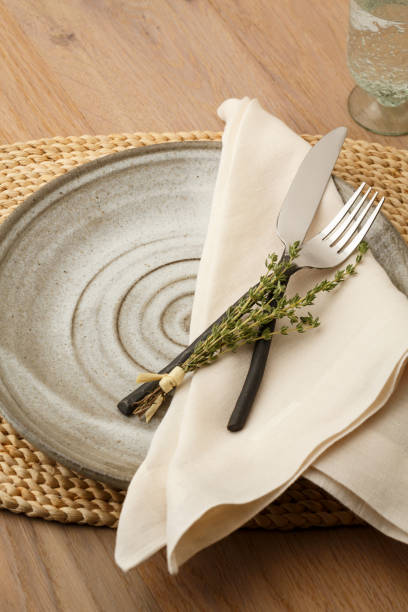 istock Natural, organic style table setting with wrought iron silverware, handmade plate, cloth napkin and fresh thyme herbs decoration 820052510