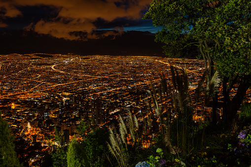 Bogota, Colombia - Looking at the Andean capital city of Bogota, Colombia in South America, from the mountain peak called Monserrate after sunset. Street lights have come on; head and tail-lights of vehicles are just streaks of lights due to the extended time exposure. To the bottom of the image is the downtown district of the City. Those who know the city, can easily recognise landmarks and principal plazas. Located at about 8500 feet above mean sea level, with a population of almost 10 Million, Bogota is one of the largest cities in Latin America. The main square, Plaza Bolivar, with the parliament building, can be seen to the centre left of the image. Photo shot late in the Blue Hour from an elevation of about 1800 feet above the City; horizontal format. Camera: Canon EOS 5D MII. Lens: Canon EF 24-70 F2.8L USM.
