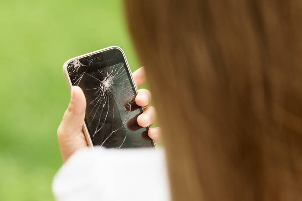 istock little girl in desperation is holding a phone with a broken screen 820054380