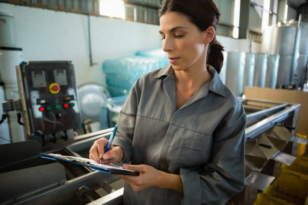 istock Female worker writing on clipboard in olive factory 820097714