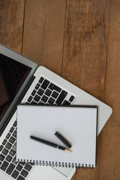 istock Laptop, pen, and diary on wooden background 820103542