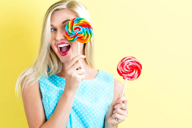 istock Young woman holding lollipops 820111600