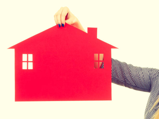 istock Woman hand holding red paper house 820123318