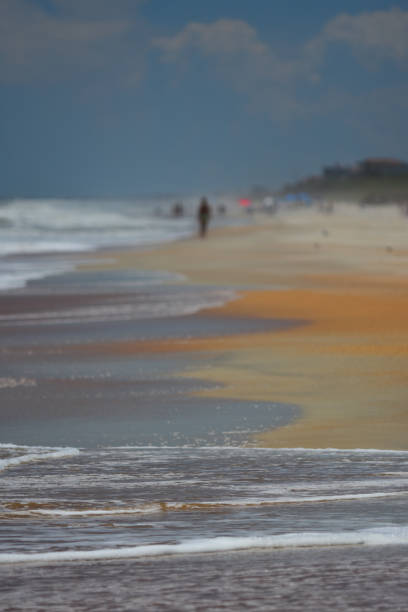 istock Surf on shell beach with defocused people in the distance 820131702
