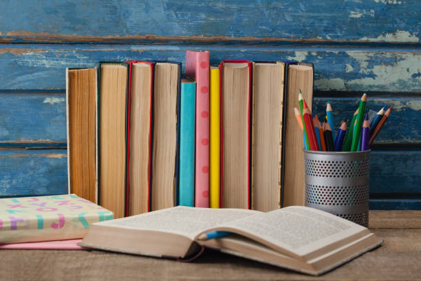 istock Stack of books, open book and pen holder 820135170