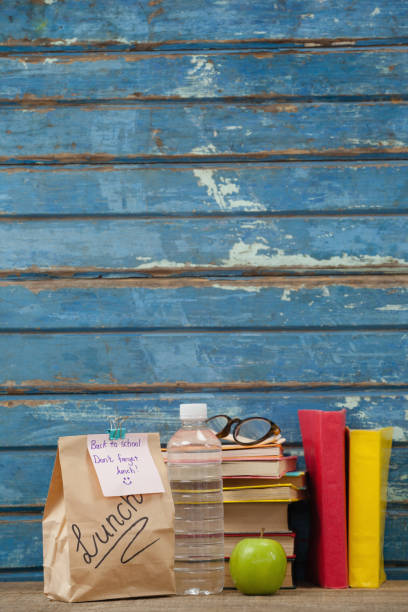 istock Stack of books, apple, water bottle, spectacles and lunch bag 820136332