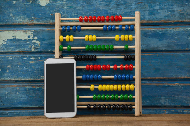 istock Abbacus game and smartphone against wooden background 820140700