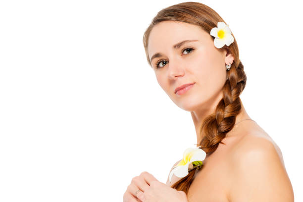 frau mit frangipani-blüten im haar close-up portrait auf weißem hintergrund - facial expression isolated lifestyles exoticism stock-fotos und bilder