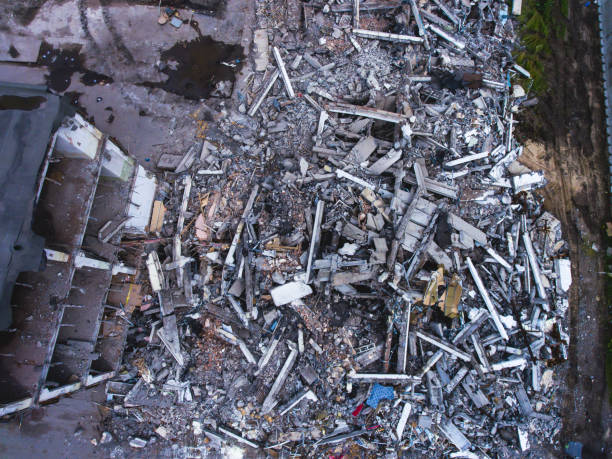 istock A process of buliding demolition, demolition site with heavy bulldozer and excavator with crushing equipment at work, demolished house, shot from air with drone 820173782