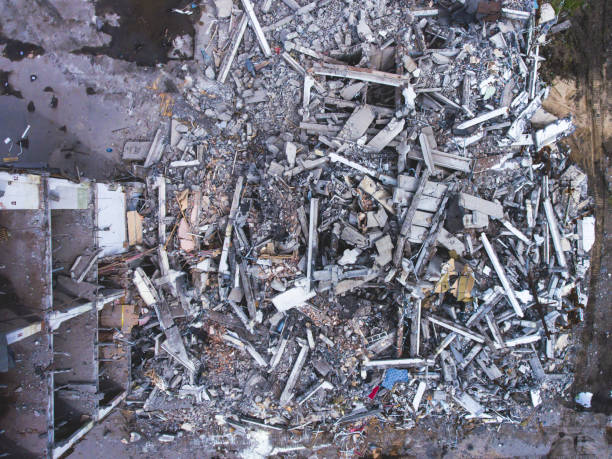 istock A process of buliding demolition, demolition site with heavy bulldozer and excavator with crushing equipment at work, demolished house, shot from air with drone 820173790