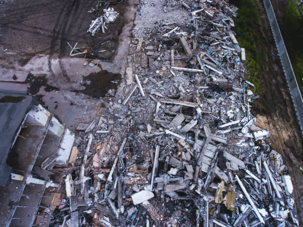istock A process of buliding demolition, demolition site with heavy bulldozer and excavator with crushing equipment at work, demolished house, shot from air with drone 820173812