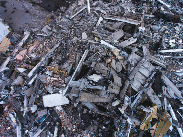 istock A process of buliding demolition, demolition site with heavy bulldozer and excavator with crushing equipment at work, demolished house, shot from air with drone 820173820