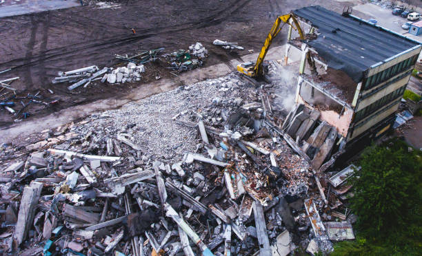 istock A process of buliding demolition, demolition site with heavy bulldozer and excavator with crushing equipment at work, demolished house, shot from air with drone 820173884
