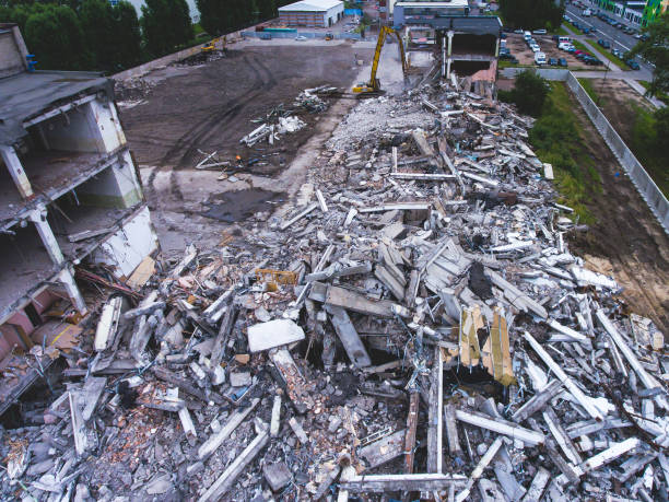 istock A process of buliding demolition, demolition site with heavy bulldozer and excavator with crushing equipment at work, demolished house, shot from air with drone 820173896