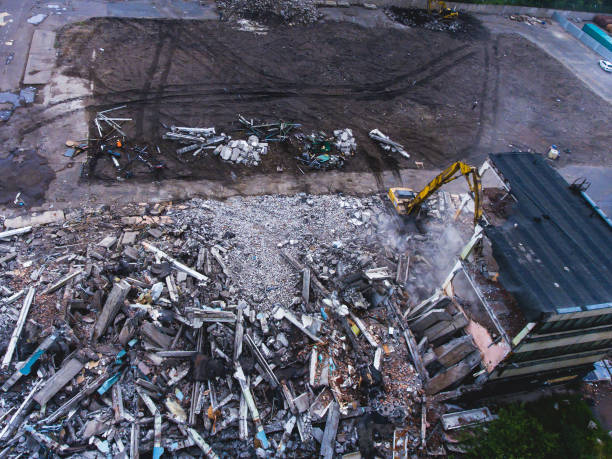 istock A process of buliding demolition, demolition site with heavy bulldozer and excavator with crushing equipment at work, demolished house, shot from air with drone 820173910