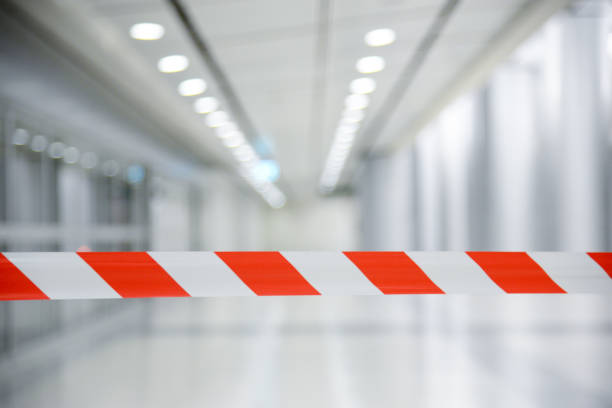 Red and White Lines of barrier tape. At subway station of airport background.Red White warning tape pole fencing is protects for No entry stock photo
