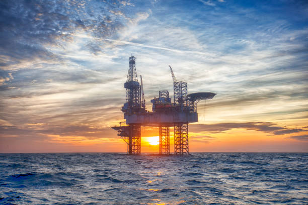 hdr of offshore jack up rig in the middle of the sea at sunset time - derrick crane drilling rig well sky imagens e fotografias de stock