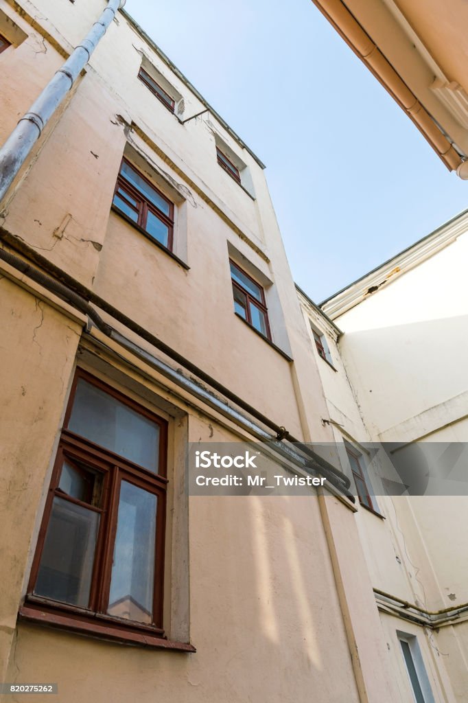 Look Upward At Rundown Apartment Buildings On Blue Sky Background Stock