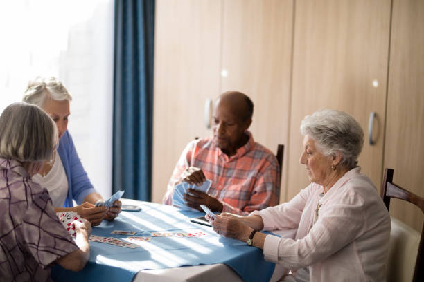 istock Senior people playing cards at table 820279686