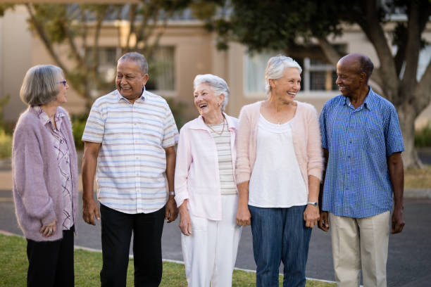 anziani allegri in piedi mentre si guardano l'un l'altro - focus on foreground joy happiness pink foto e immagini stock