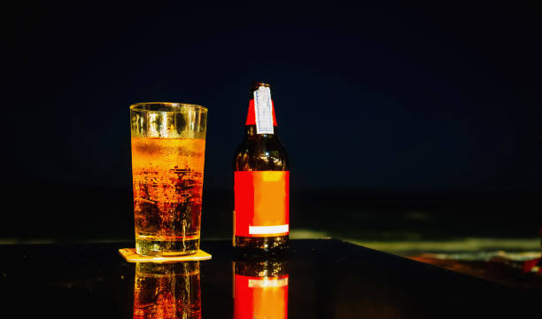 istock Bottle and grass of beer on the table at the beach during night time. 820282910