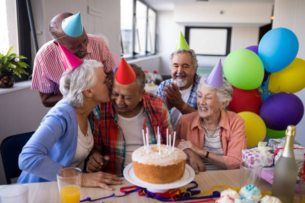 istock Friend kissing senior man while celebrating at party 820304980
