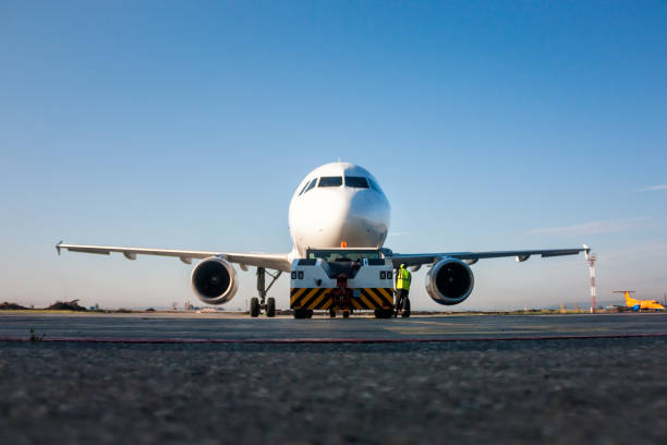 istock Tow truck is pushing back the passenger airplane 820311682