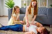 Mother and two daughters playing and tickling