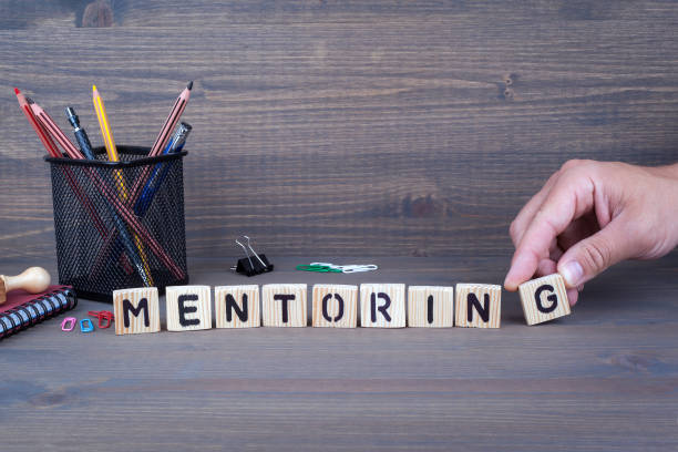 istock mentoring. Wooden letters on dark background 820321396