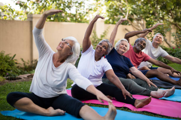 istock Senior people with arms raised exercising at park 820349776