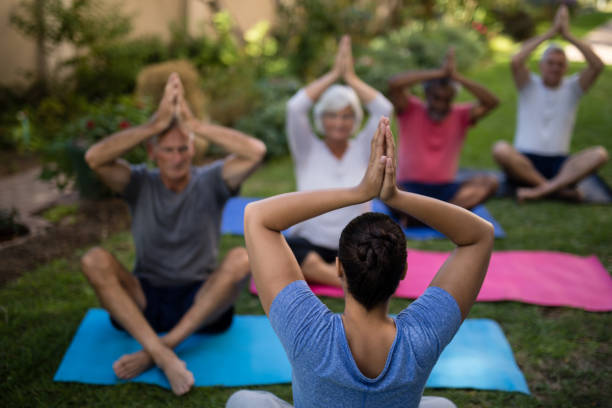 istock Trainer meditating with senior men and women 820350982