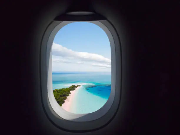 Airplane window with paradisaical beach and sea View
