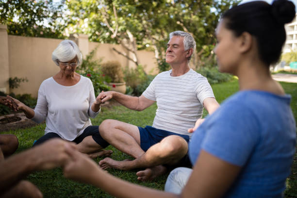 istock Senior people holding hands and meditating with trainer 820356280