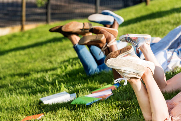 istock Partial view of students lying on green grass in park 820361888