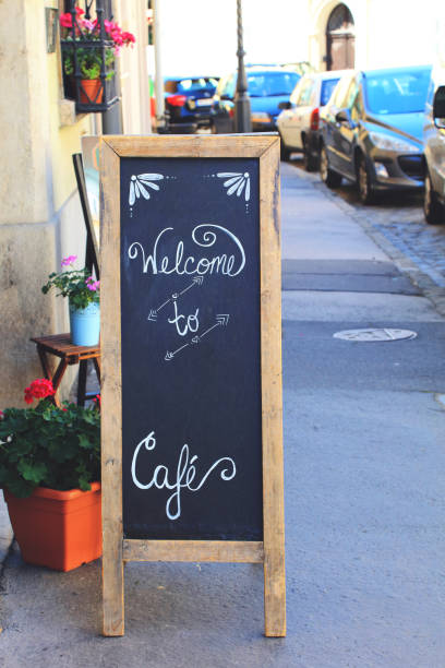 istock Restaurant blackboard sign 'Welcome to Cafe' on footpath, copy space 820366632