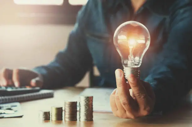 Photo of business accountin with saving money with hand holding lightbulb concept financial background