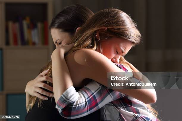 Two Sad Teens Embracing At Bedroom Stock Photo - Download Image Now - Embracing, Sadness, Teenager