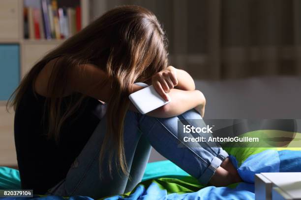 Adolescente Triste Con Un Telefono Nella Sua Camera Da Letto - Fotografie stock e altre immagini di Adolescente