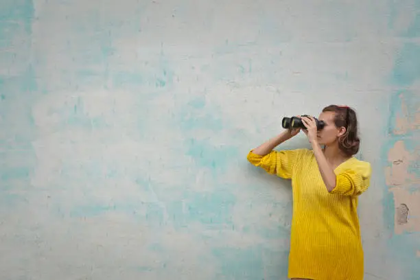 woman with binoculars on green background