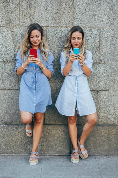 istock Twins texting in the city 820390776