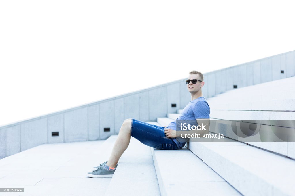 Young adult man portrait Young adult man sitting on stairs portrait. 20-24 Years Stock Photo