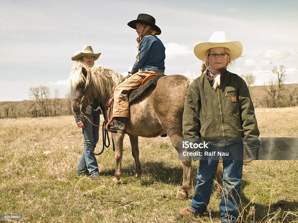 Sisters with Shetland pony on prarie Cowgirl sisters on Shetland pony on family ranch in Big Timber, Montana Old-fashioned Stock Photo