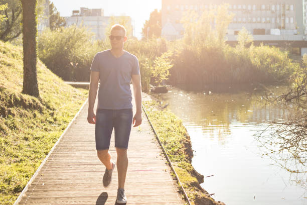 istock Young adult man walking in park 820397886