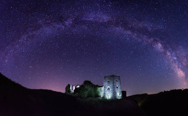 Arch of Milky way over the old castle. Ruins of Herburt's Castle in Kudryntsi, Ukraine