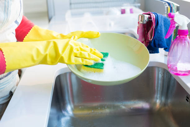 istock Woman washing plate with sponge in kitchen sink 820416046